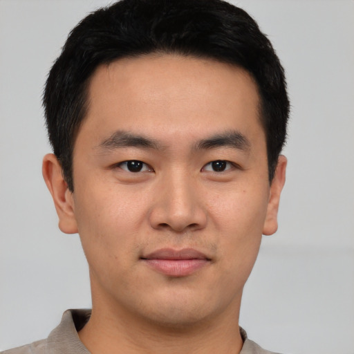 Joyful asian young-adult male with short  black hair and brown eyes