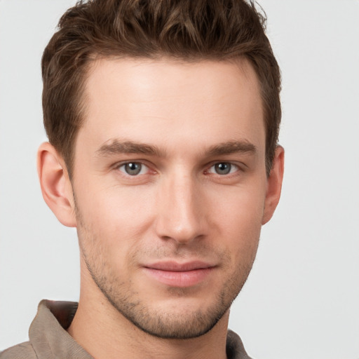 Joyful white young-adult male with short  brown hair and grey eyes