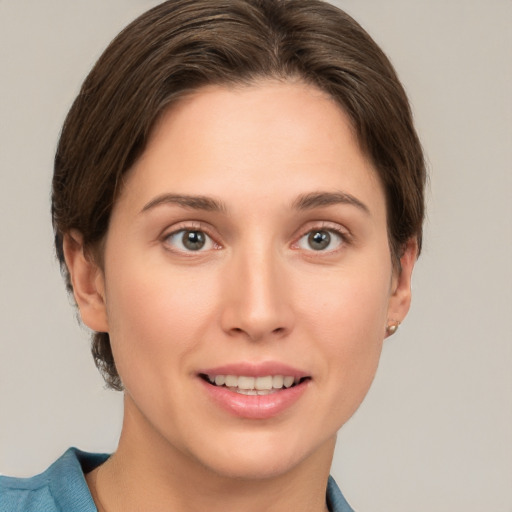 Joyful white young-adult female with short  brown hair and grey eyes