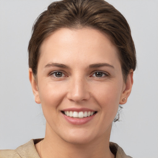 Joyful white young-adult female with short  brown hair and grey eyes