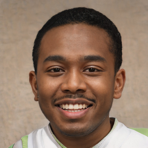 Joyful black young-adult male with short  black hair and brown eyes