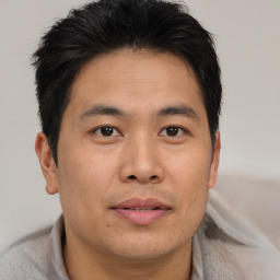 Joyful asian young-adult male with short  brown hair and brown eyes