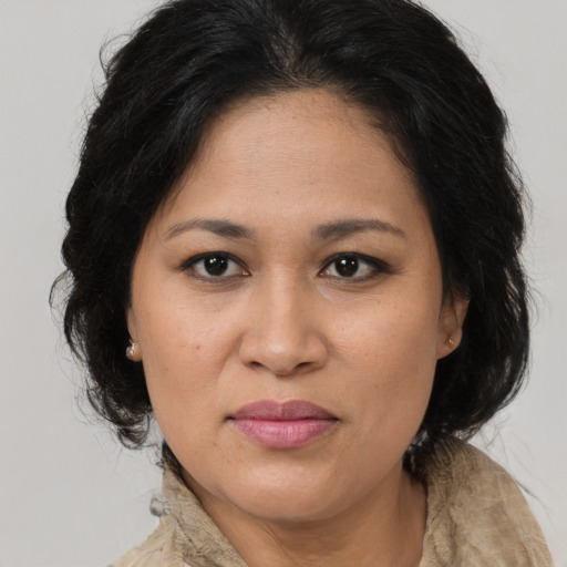 Joyful latino adult female with long  brown hair and brown eyes