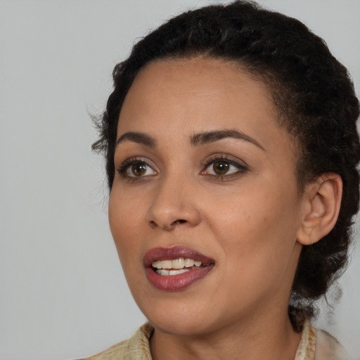 Joyful black young-adult female with long  brown hair and brown eyes