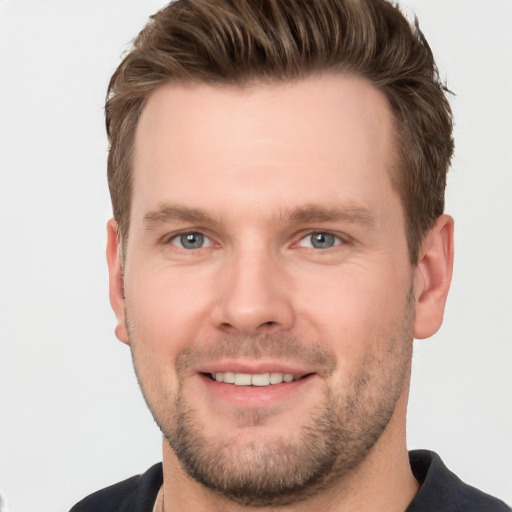 Joyful white young-adult male with short  brown hair and grey eyes