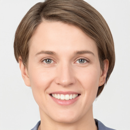 Joyful white young-adult female with short  brown hair and grey eyes