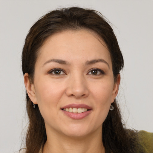 Joyful white young-adult female with long  brown hair and brown eyes