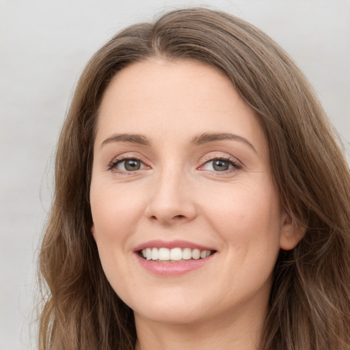 Joyful white young-adult female with long  brown hair and green eyes