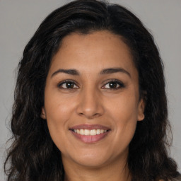 Joyful latino young-adult female with long  brown hair and brown eyes