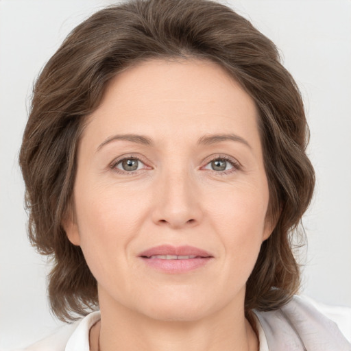 Joyful white adult female with medium  brown hair and grey eyes