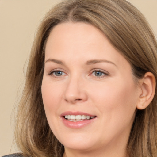 Joyful white adult female with long  brown hair and brown eyes