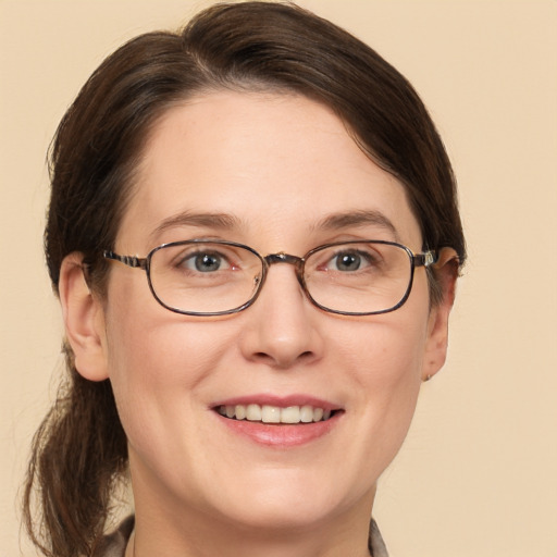 Joyful white adult female with medium  brown hair and grey eyes