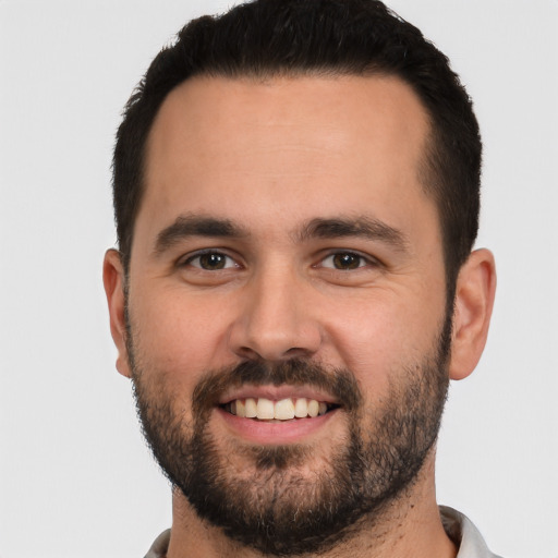 Joyful white young-adult male with short  black hair and brown eyes