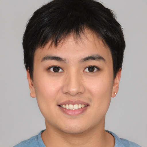 Joyful asian young-adult male with short  brown hair and brown eyes