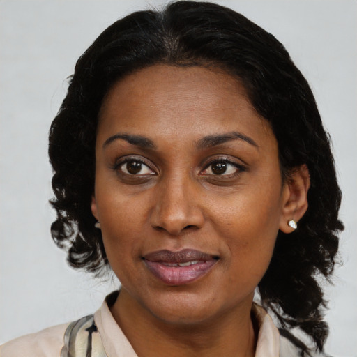 Joyful black adult female with medium  brown hair and brown eyes