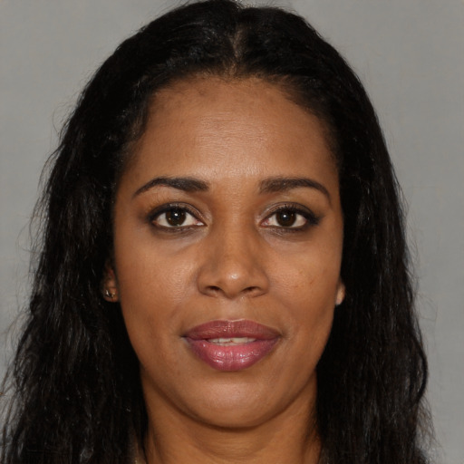 Joyful black young-adult female with long  black hair and brown eyes