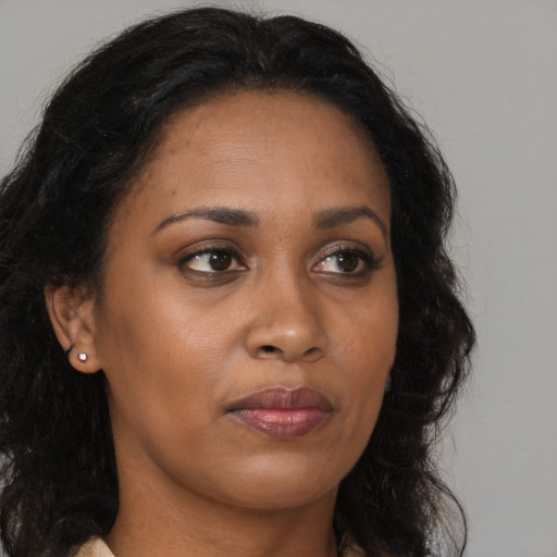 Joyful black adult female with long  brown hair and brown eyes
