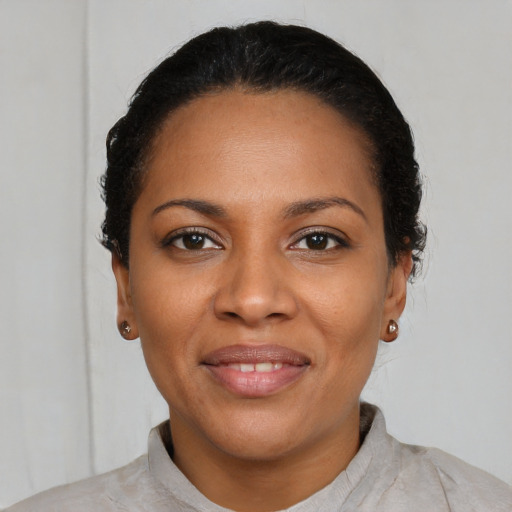 Joyful black young-adult female with short  black hair and brown eyes