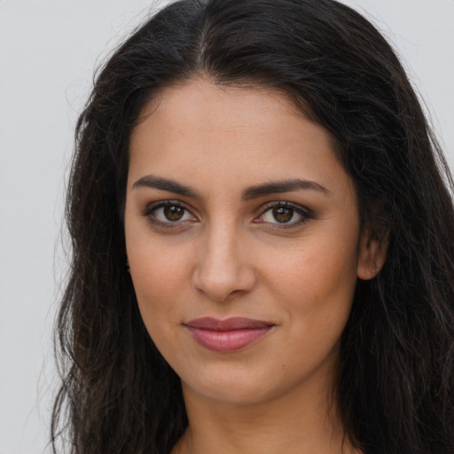 Joyful latino young-adult female with long  brown hair and brown eyes