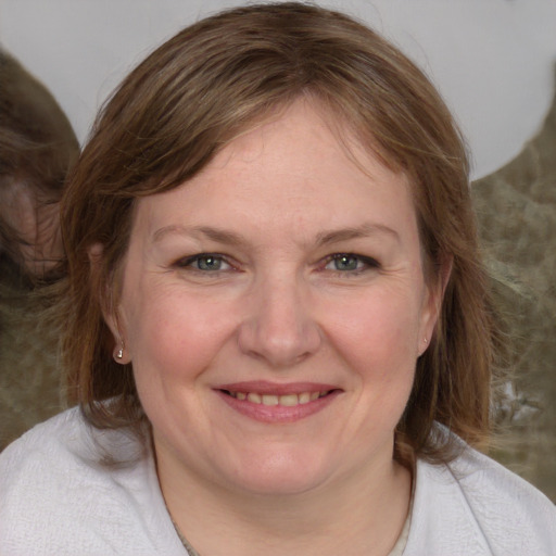 Joyful white adult female with medium  brown hair and blue eyes