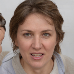 Joyful white adult female with medium  brown hair and blue eyes