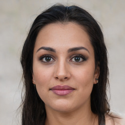 Joyful latino young-adult female with long  brown hair and brown eyes