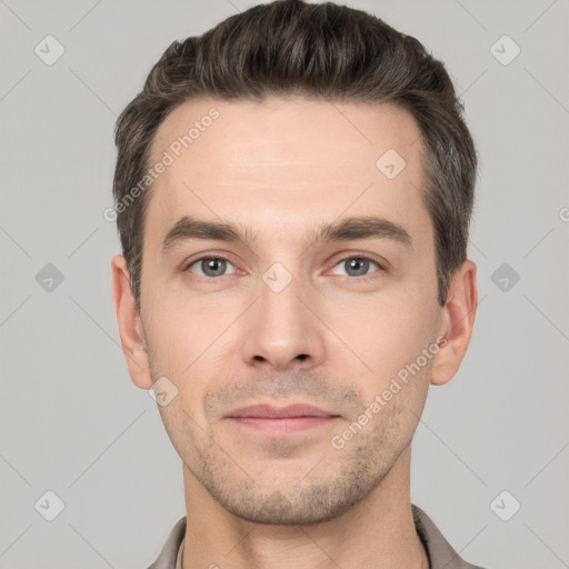 Joyful white young-adult male with short  brown hair and grey eyes