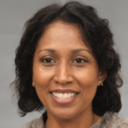 Joyful black adult female with medium  brown hair and brown eyes