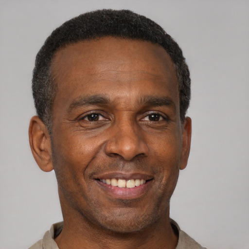 Joyful black adult male with short  brown hair and brown eyes