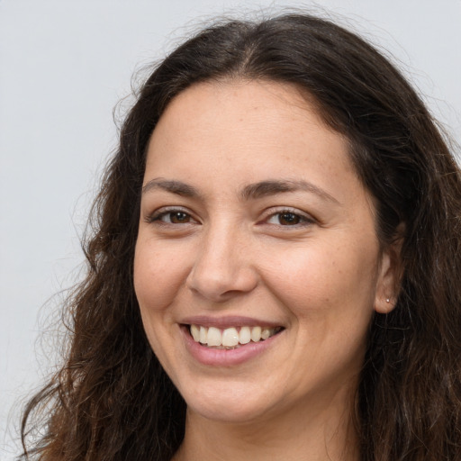 Joyful white adult female with long  brown hair and brown eyes