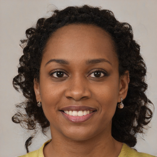 Joyful black young-adult female with medium  brown hair and brown eyes