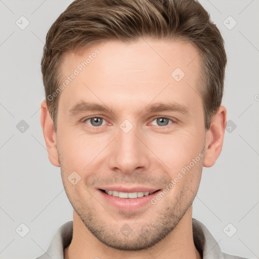 Joyful white young-adult male with short  brown hair and grey eyes