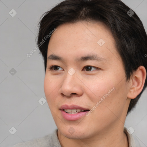 Joyful asian young-adult male with short  brown hair and brown eyes