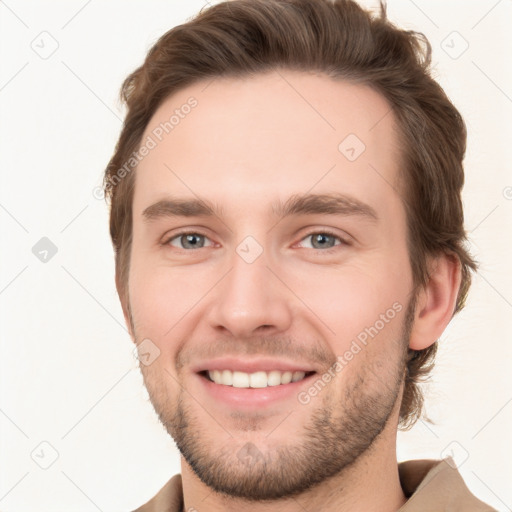 Joyful white young-adult male with short  brown hair and grey eyes