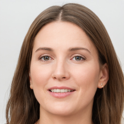 Joyful white young-adult female with long  brown hair and grey eyes