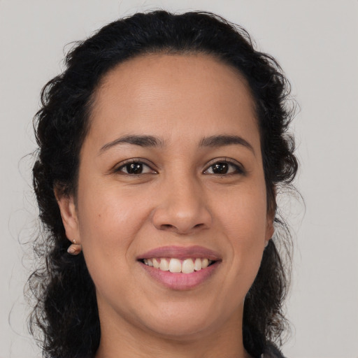 Joyful latino young-adult female with medium  brown hair and brown eyes