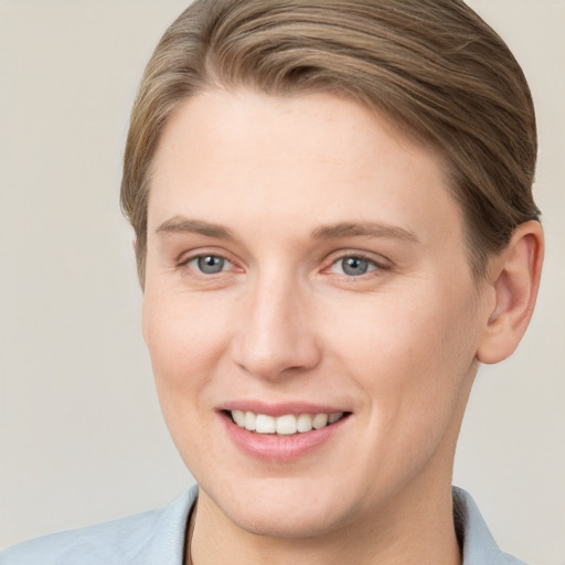 Joyful white young-adult female with short  brown hair and grey eyes