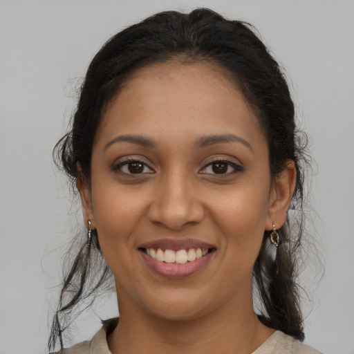 Joyful latino young-adult female with medium  brown hair and brown eyes