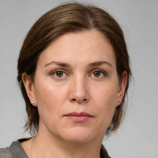 Joyful white young-adult female with medium  brown hair and green eyes