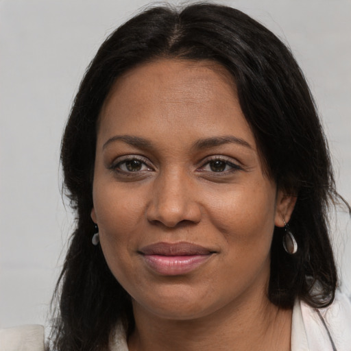 Joyful black young-adult female with long  brown hair and brown eyes