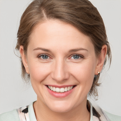 Joyful white young-adult female with medium  brown hair and grey eyes