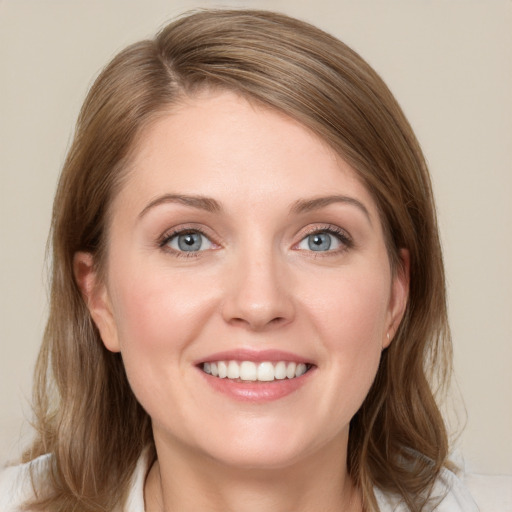 Joyful white young-adult female with medium  brown hair and blue eyes