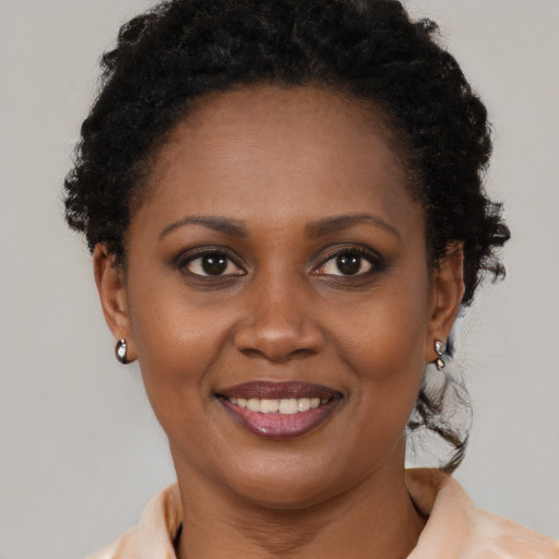 Joyful black young-adult female with short  brown hair and brown eyes