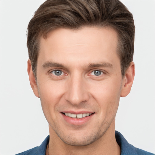 Joyful white young-adult male with short  brown hair and grey eyes