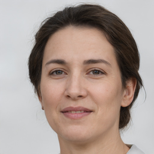 Joyful white adult female with medium  brown hair and brown eyes