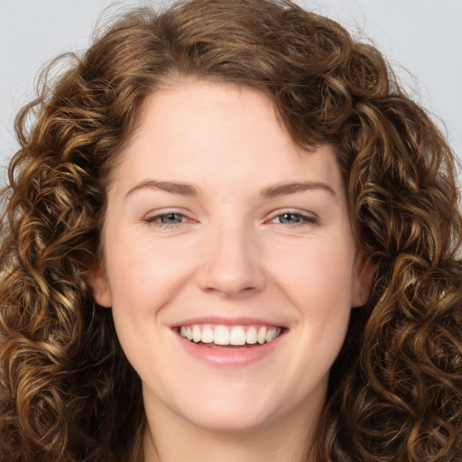 Joyful white young-adult female with long  brown hair and green eyes