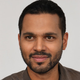 Joyful black young-adult male with short  black hair and brown eyes