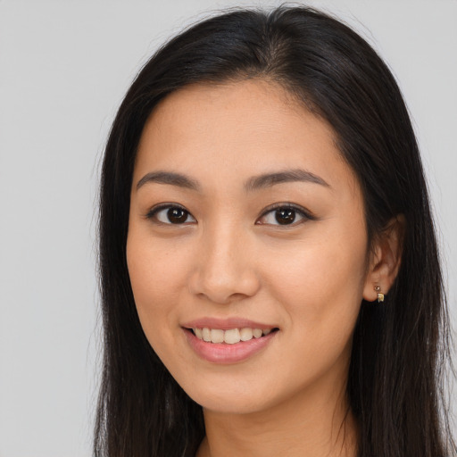 Joyful latino young-adult female with long  brown hair and brown eyes
