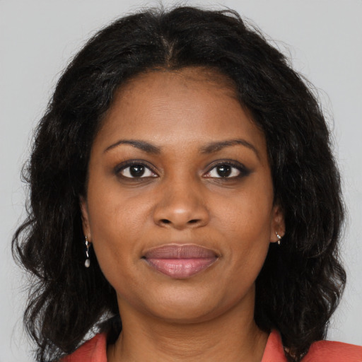 Joyful black young-adult female with long  brown hair and brown eyes