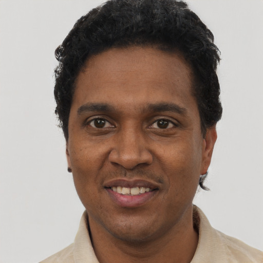 Joyful black young-adult male with short  black hair and brown eyes